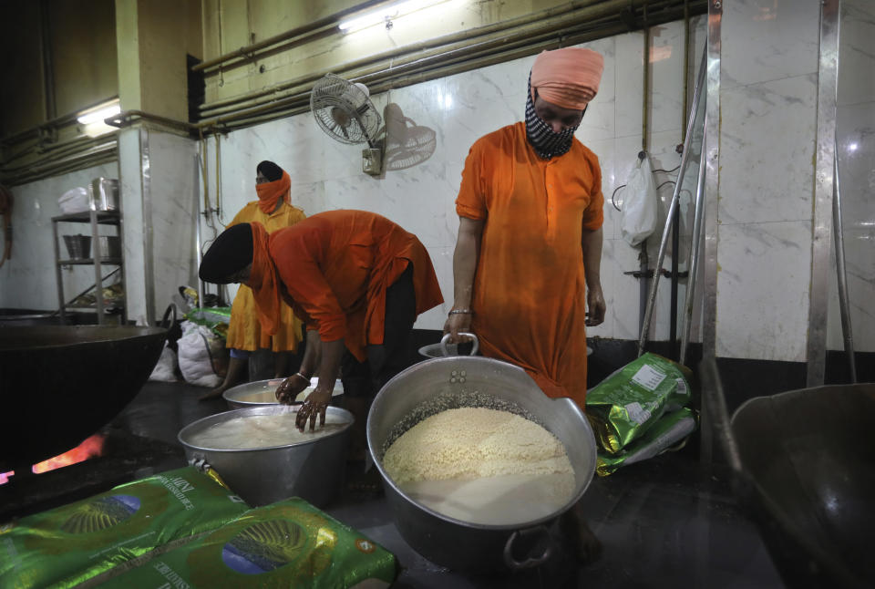 Sikh volunteers wash rice before it is coked in the kitchen hall of the Bangla Sahib Gurdwara in New Delhi, India, Sunday, May 10, 2020. The Bangla Sahib Gurdwara has remained open through wars and plagues, serving thousands of people simple vegetarian food. During India's ongoing coronavirus lockdown about four dozen men have kept the temple's kitchen open, cooking up to 100,000 meals a day that the New Delhi government distributes at shelters and drop-off points throughout the city. (AP Photo/Manish Swarup)