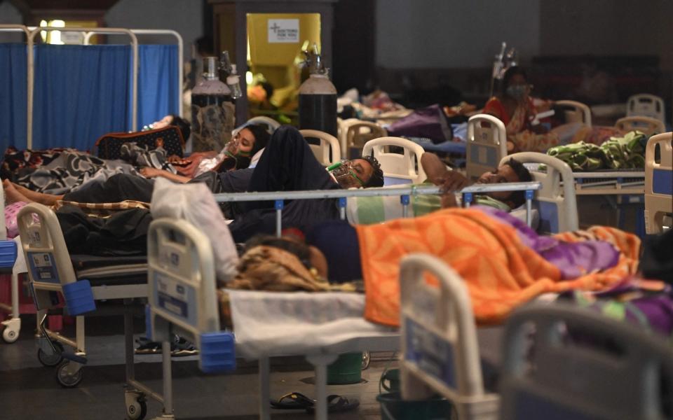 Patients breath with the help of oxygen masks inside a banquet hall temporarily converted into a Covid-19 coronavirus ward in New Delhi on April 27, 2021. - MONEY SHARMA /AFP