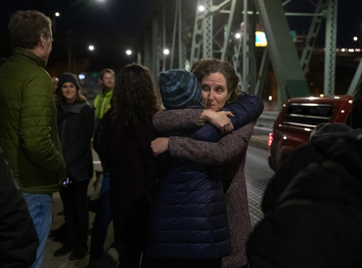 In a photo provided by Multnomah County, Dr. Jennifer Vines, lead regional health officer for the Portland metro area, hugs a county employee after moment of silence Thursday, March 10, 2022, in Portland, Ore., during an event marking two years since the first case of COVID-19 was confirmed in Portland. (Motoya Nakamura/Multnomah County via AP)