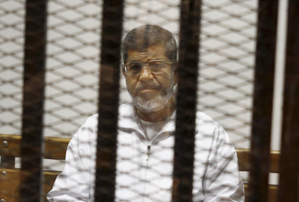 FILE - In this May 8, 2014 file photo, Egypt's ousted Islamist President Mohammed Morsi sits in a defendant cage in the Police Academy courthouse in Cairo, Egypt. Morsi’s collapse and death in a Cairo courtroom on June 17, 2019, was a brief rallying point for the Muslim Brotherhood whose influence waned dramatically in the Middle East since the 2013 military coup in Egypt which had widespread public support at the time. The long-running enmity between the Brotherhood and most Sunni-led governments highlights the deep divisions among Sunni Muslims. It adds a further complication to the volatile region, where the split between Sunnis and Shiite Muslims has created rival camps. (AP Photo/Tarek el-Gabbas, File)