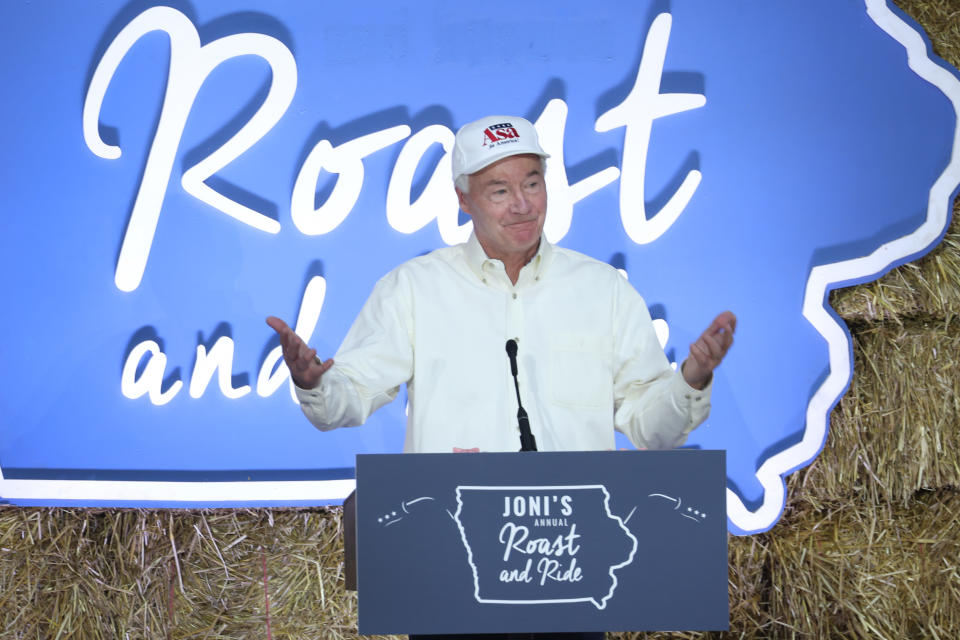 Asa Hutchinson stands at a podium that reads: Joni's annual Roast and Ride.