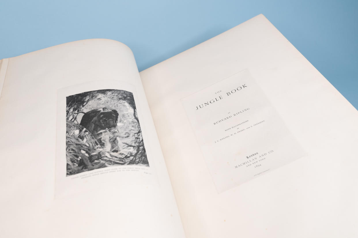 A book open on a table. One page has a detailed realistic drawing of an elephant and the opposite is the title page for 'The Jungle Book'