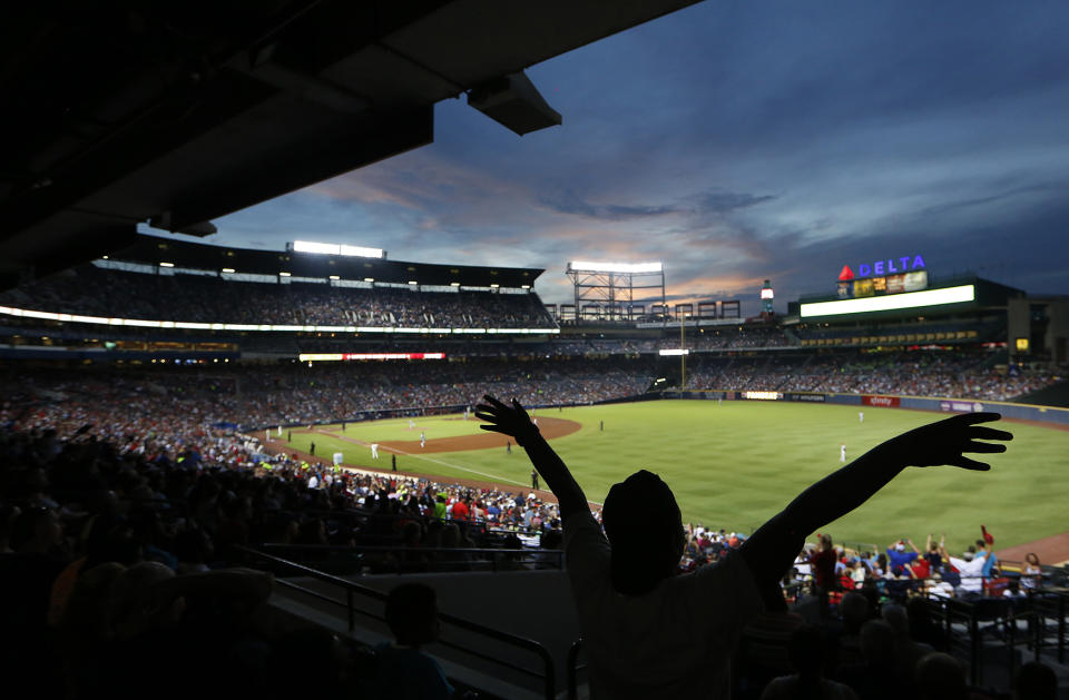 <p>A fan waves as the sun sets behind Turner Field during a baseball game between the Philadelphia Phillies and the Atlanta Braves, July 30, 2016, in Atlanta. (Photo: John Bazemore/AP) </p>