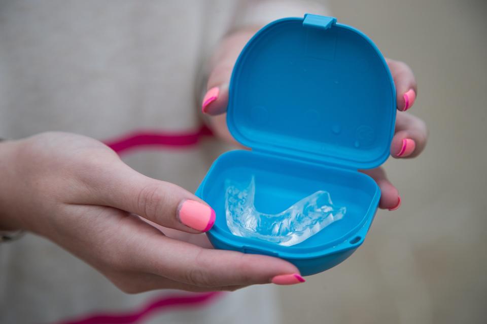 Sarah Stovall, 20, of Grosse Pointe, shows her dental guard in Detroit on Saturday, Aug. 13, 2022.