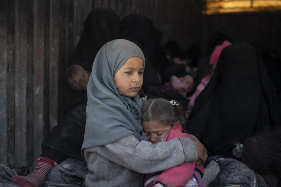 Children ride in the back of a truck that is part of a convoy evacuating hundreds out of the last territory held by Islamic State militants, in Baghouz, eastern Syria, Wednesday, Feb. 20, 2019. The evacuation signals the end of a week long standoff and opens the way to U.S.-backed Syrian Democratic Forces (SDF) recapture the territory. (AP Photo/Felipe Dana)