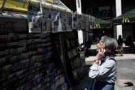 A woman reads newspapers' headlines at a kiosk in Athens, on June 4, 2015