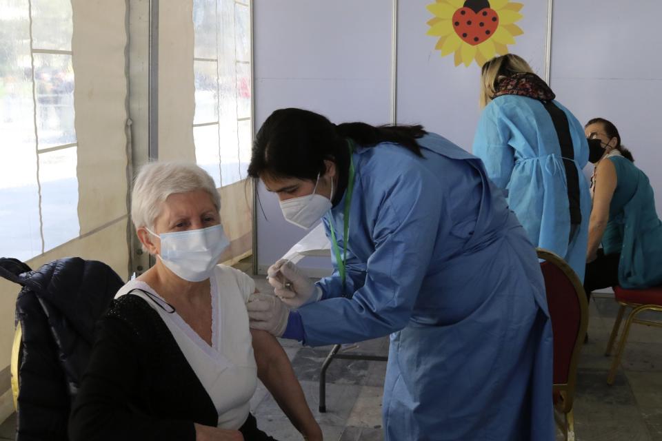 An elderly woman receives a dose of Sinovac COVID-19 vaccine in Tirana, Albania, Sunday, March 28, 2021. Albania started a mass vaccination campaign trying to inoculate half a million people opening the way to a more relaxed incoming summer tourism season. (AP Photo/Hektor Pustina)