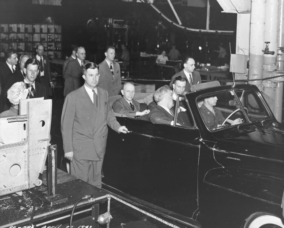 A photo of President Roosevelt visiting Evansville on April 27, 1943. Roosevelt toured Republic Aviation Corporation Plant, which manufactured the P-47 Thunderbolt planes. This photo shows the president riding through the plant with Secret Service agents walking along side the car.