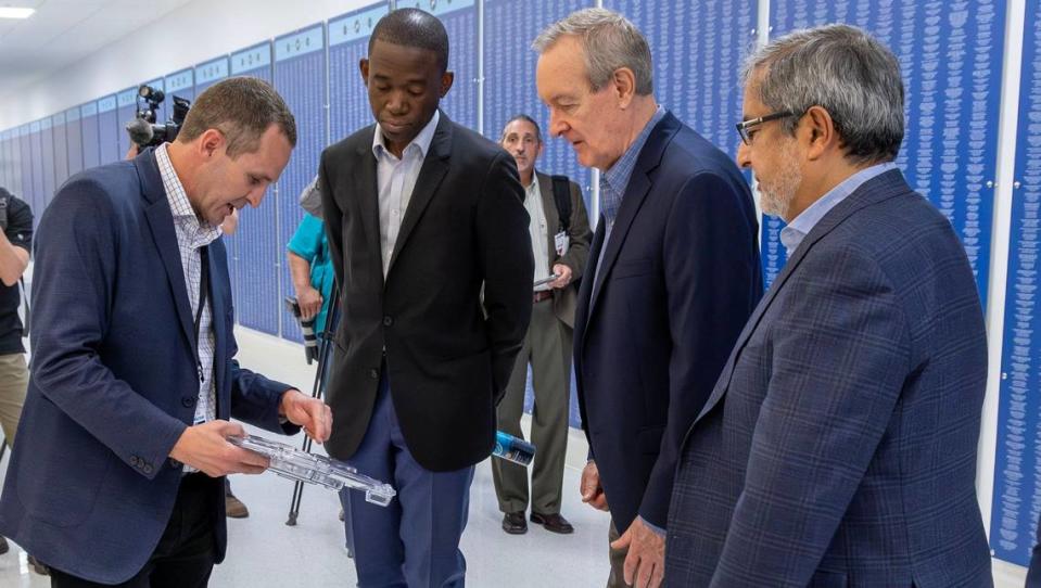 Micron Technology Senior Director of U.S. Expansion Planning Jeff Binford, left, shows a sample wafer of semiconducter chips while on a tour with Deputy Secretary of the Treasury Wally Adeyemo, U.S. Sen. Mike Crapo, and Micron CEO Sanjay Mehrotra, right.