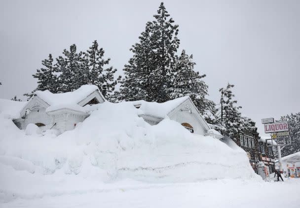 PHOTO: Brian Dunham shovels snow near snowbanks piled up from previous storms during another winter storm in the Sierra Nevada mountains on March 10, 2023, in Mammoth Lakes, Calif. (Mario Tama/Getty Images)
