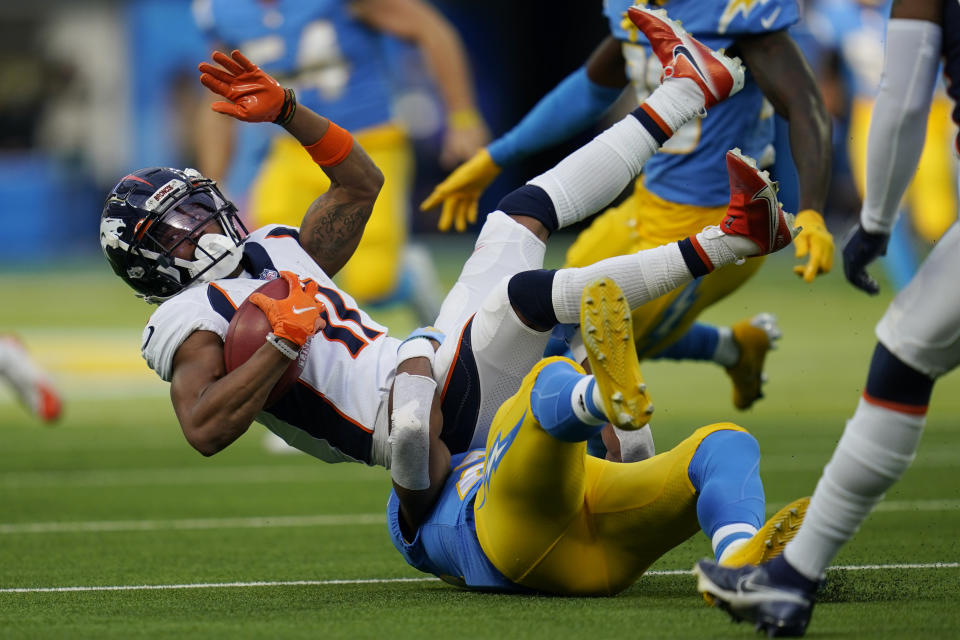 Denver Broncos wide receiver Diontae Spencer, top, is tackled by Los Angeles Chargers' Justin Jackson on a punt return during the first half of an NFL football game Sunday, Jan. 2, 2022, in Inglewood, Calif. (AP Photo/Ashley Landis )