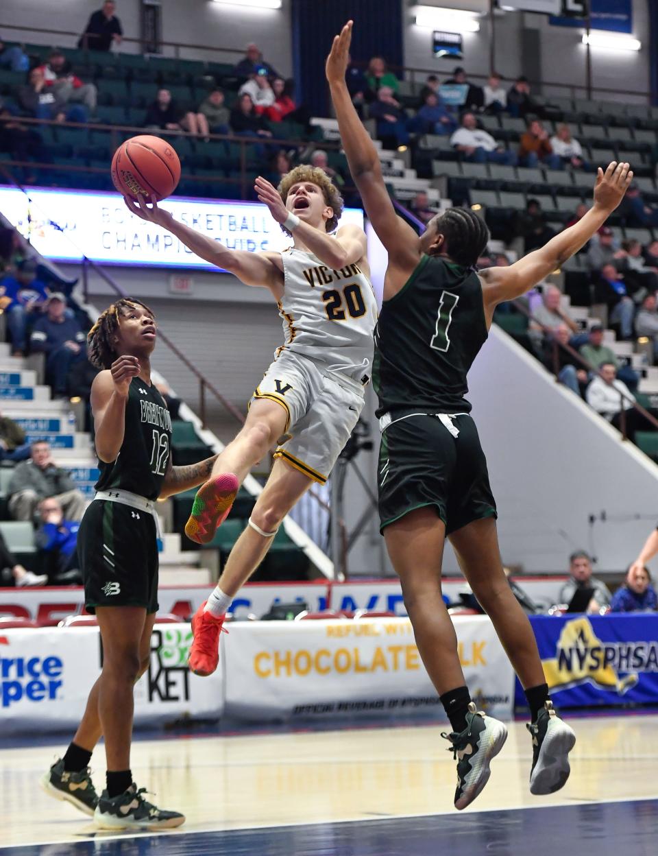 Victor's Griffen Hopkins (20) drives to the basket between Brentwood's Marquese Dennis, left, and Frederic Diogene during a NYSPHSAA Class AA Boys Basketball Championship semifinal in Glens Falls, N.Y., Friday, March 17, 2023. Victor advanced to the Class AA title game with a 56-41 win over Brentwood-XI.