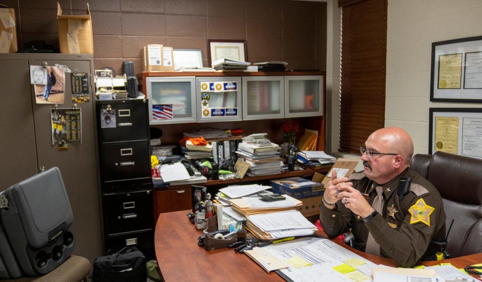 Tobe Leazenby, Sheriff of Carroll County, looks at a grainy cell phone image and sketch of the a prime suspect (upper left corner of image), in the 2017 death of girls Abigail Williams and Liberty German, in Delphi, Monday, Oct. 31, 2022. Finishing out his second and final term, Leazenby kept the images there to remind him of the ongoing interagency investigation that yielded the recent arrest of Richard M. Allen.