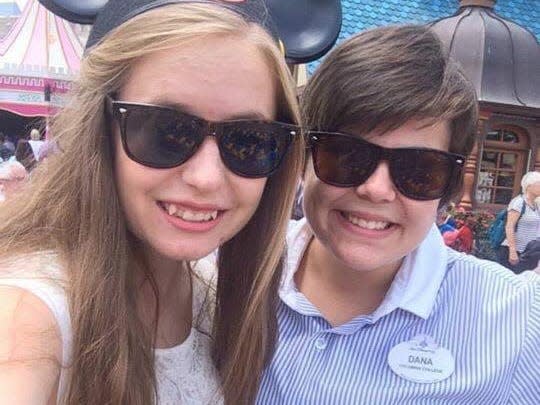 dana working at disney and posing with someone wearing a mickey mouse hat