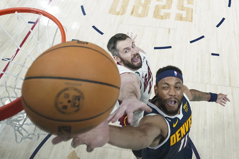 Denver Nuggets forward Bruce Brown, right, shoots while defended by Miami Heat forward Kevin Love during the first half of Game 2 of basketball's NBA Finals, Sunday, June 4, 2023, in Denver. (AP Photo/Mark J. Terrill, Pool)