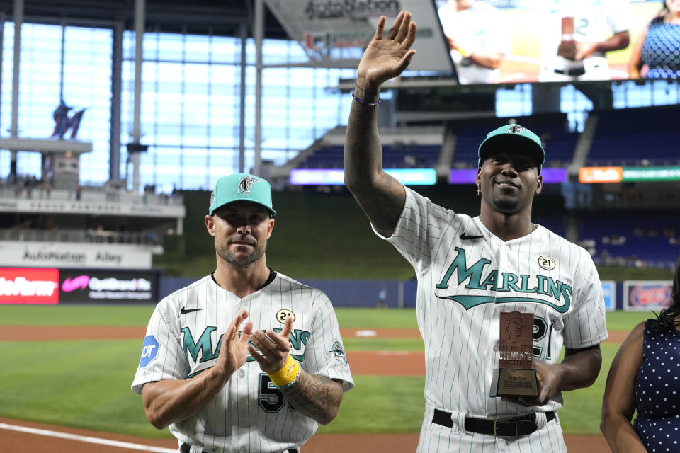 Miami Marlins' Jorge Soler, right, waves as he stands with team manager Skip Schumaker, right, during a ceremony before a baseball game against the Atlanta Braves, Friday, Sept. 15, 2023, in Miami. Soler is the Marlins' nominee for the Roberto Clemente Award. (AP Photo/Lynne Sladky)
