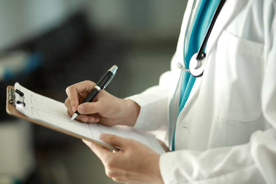 Doctor in a white coat writing on a clip board to diagnose Tuberculosis 