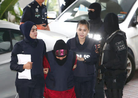 Indonesian Siti Aisyah, who is on trial for the killing of Kim Jong Nam, the estranged half-brother of North Korea's leader, is escorted as she arrives at the Shah Alam High Court on the outskirts of Kuala Lumpur, Malaysia January 22, 2018. REUTERS/Lai Seng Sin