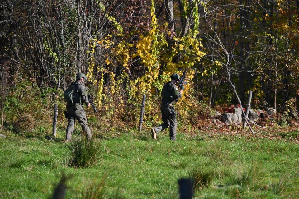 Law enforcement personnel search a wooded area in Monmouth, Maine, amid the search for shooting suspect Robert Card (AFP via Getty Images)