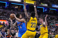 Oklahoma City Thunder forward Jaylin Williams (6) gets trapped by Indiana Pacers forward Aaron Nesmith (23) and guard T.J. McConnell (9) during the first half of an NBA basketball game in Indianapolis, Friday, March 31, 2023. (AP Photo/Michael Conroy)