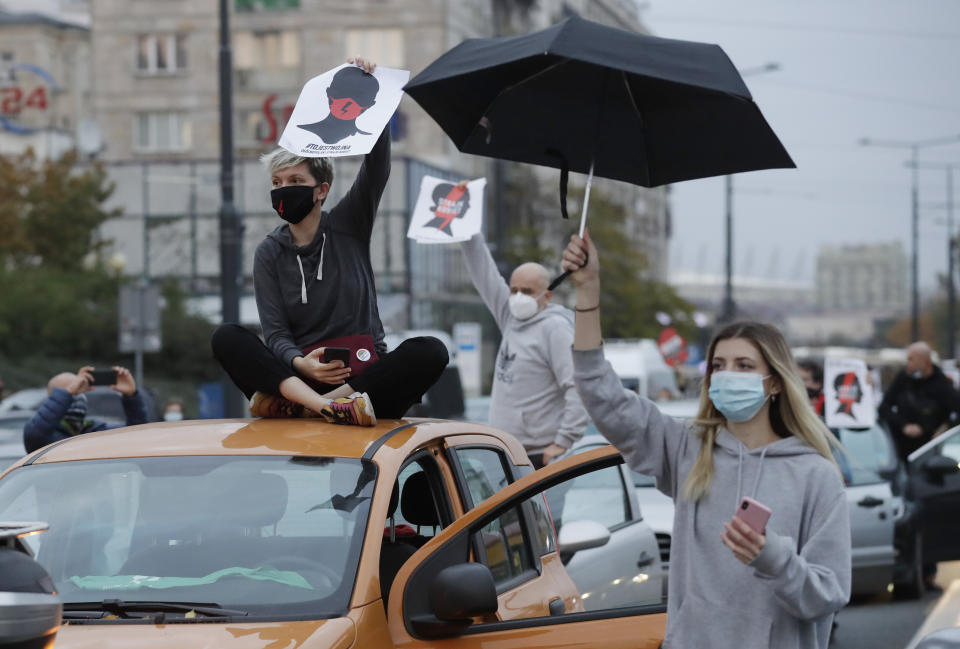 Angered women's rights activists and their supporters block rush-hour traffic at a major roundabout on the fifth day of nationwide protests against recent court ruling that tightened further Poland's restrictive abortion law, in Warsaw, Poland, on Monday, Oct. 26, 2020. The court effectively banned almost all abortions. (AP Photo/Czarek Sokolowski)
