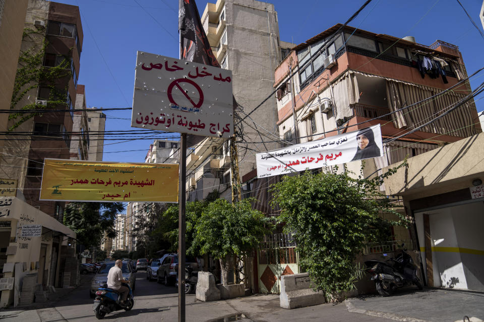 Condolences banners hang next to the house of Mariam Farhat Hamdar, who was killed during the deadly clashes that erupted last Thursday along a former 1975-90 civil war front-line between Muslim Shiite and Christian areas, in the Chiyah neighborhood of Beirut, Lebanon, Tuesday, Oct. 19, 2021. Arabic on the banner reads: "Condolences to the Lord of the Age (the Last of the 12th Shiite Imams) for the martyred unjustly Mariam Farhat Hamdar (or Um Haidar)". (AP Photo/Hassan Ammar)