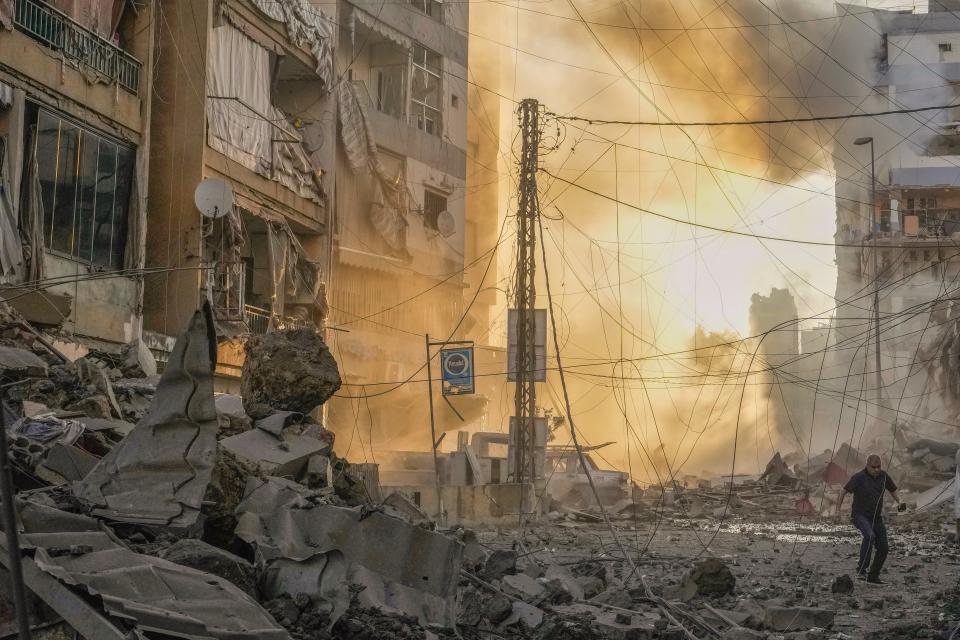 A man runs for cover as smoke rises in the background following an Israeli airstrike in Dahiyeh, Beirut, Lebanon, on Friday (Copyright 2024 The Associated Press. All rights reserved)