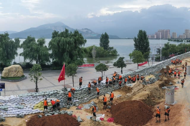 Chinese soldiers build a temporary embankment to contain Poyang Lake which has reached a record level threatening to flood Lushan city in central China’s Jiangxi province 