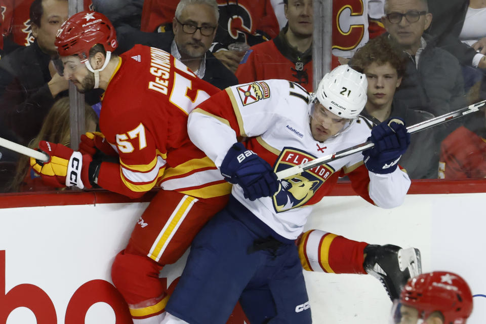 Calgary Flames defenseman Nick DeSimone, right, is hit by Florida Panthers center Nick Cousins during the first period of an NHL hockey game in Calgary, Alberta., Monday, Dec. 18, 2023. (Larry MacDougal/The Canadian Press via AP)