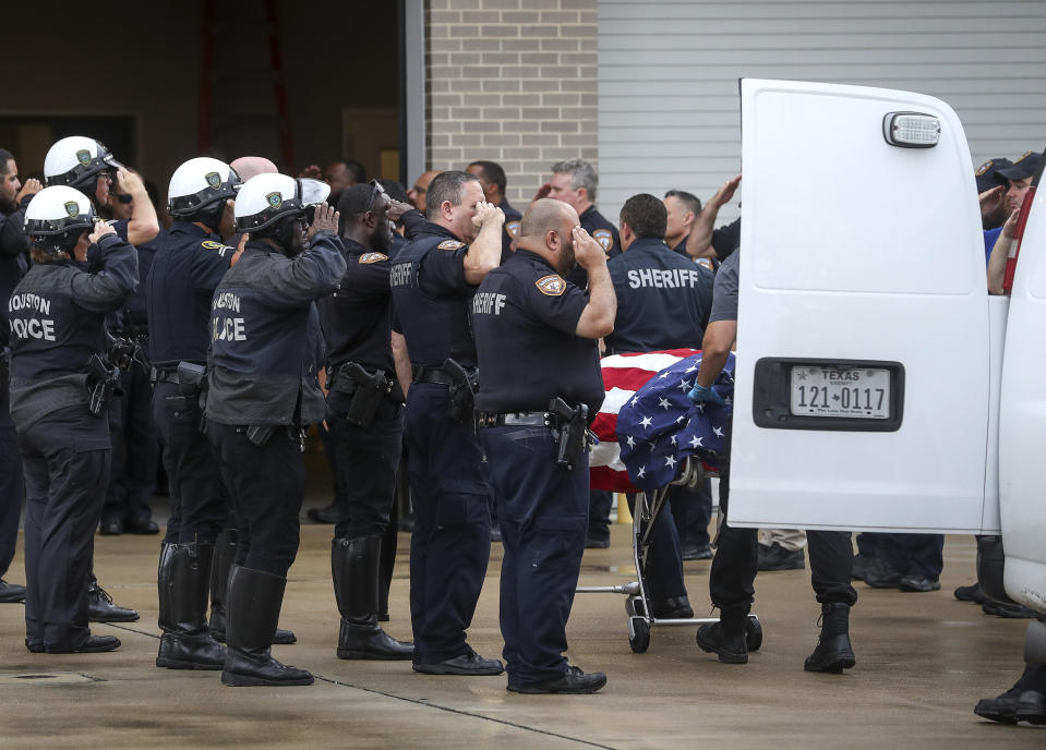 Law enforcement officers escort the body of Deputy Sandeep Dhaliwal, who was shot and killed after a traffic stop in Cypress earlier in the day, to the Harris County Institute of Forensic Sciences on Friday, Sept. 27, 2019, in Houston. (Jon Shapley/Houston Chronicle via AP)