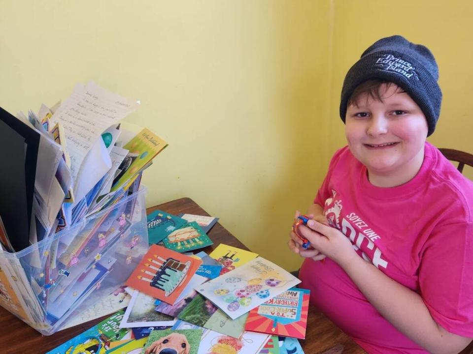 Joey Connolly, wearing a P.E.I. tuque, goes through his birthday cards.  (Renee Connolly - image credit)