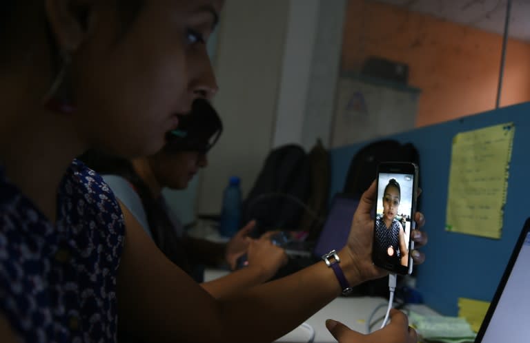 An employee of Indian tech company Frankly.me uses a phone to test their app at an office in Noida on the outskirts of New Delhi on June 30, 2015