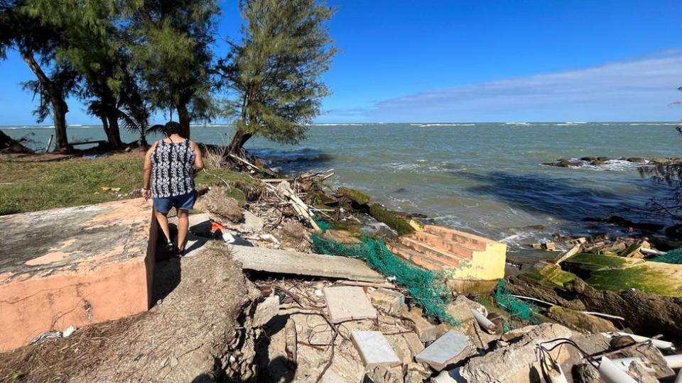 Janet Quiñones camina por un predio ubicado detrás de su casa en el que antes habían otras casas y ahora hay escombros.