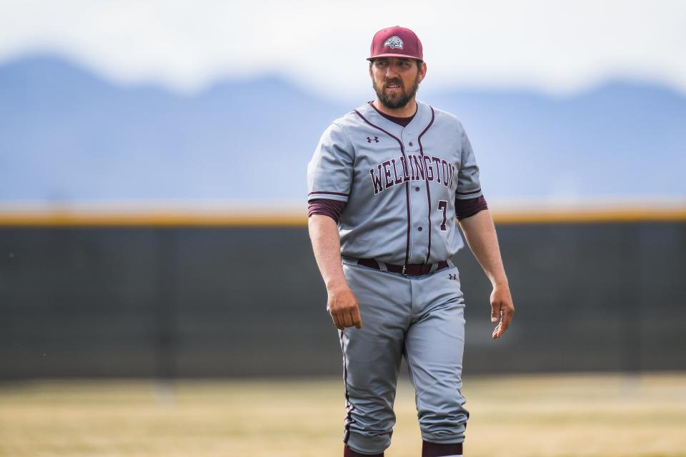 Wellington head coach Alvin Hastings surveys the field from third base during a high school baseball game against Timnath at Timnath Middle-High School on Wednesday, April 12, 2023, in Timnath, Colo.