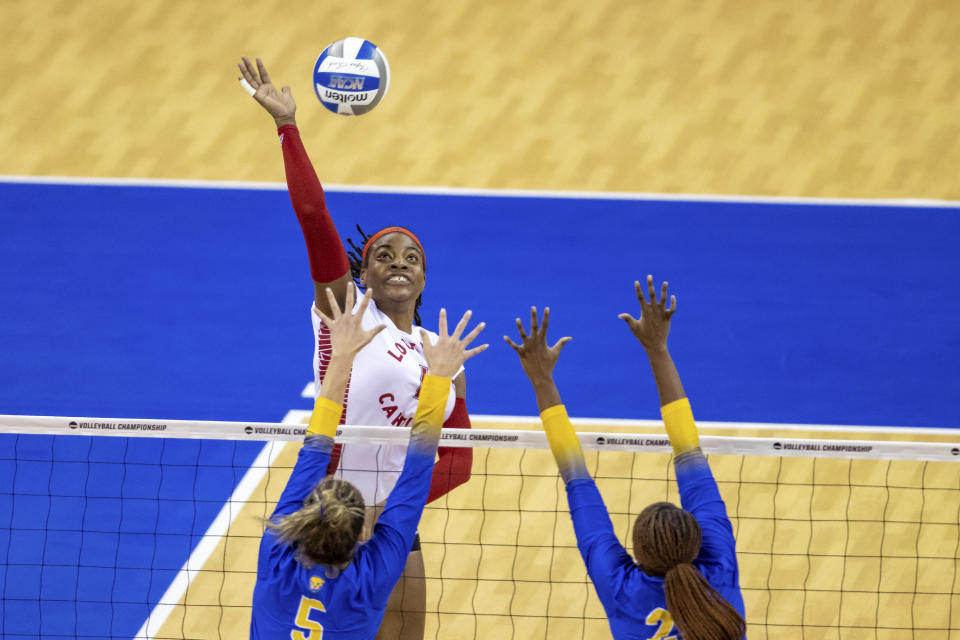 Louisville's Aiko Jones (15) spikes the ball against Pittsburgh's Cam Ennis (5) and Chiamaka Nwokolo (20) in the second set during the semifinals of the NCAA volleyball tournament, Thursday, Dec. 15, 2022 in Omaha, Neb. (AP Photo/John S. Peterson)