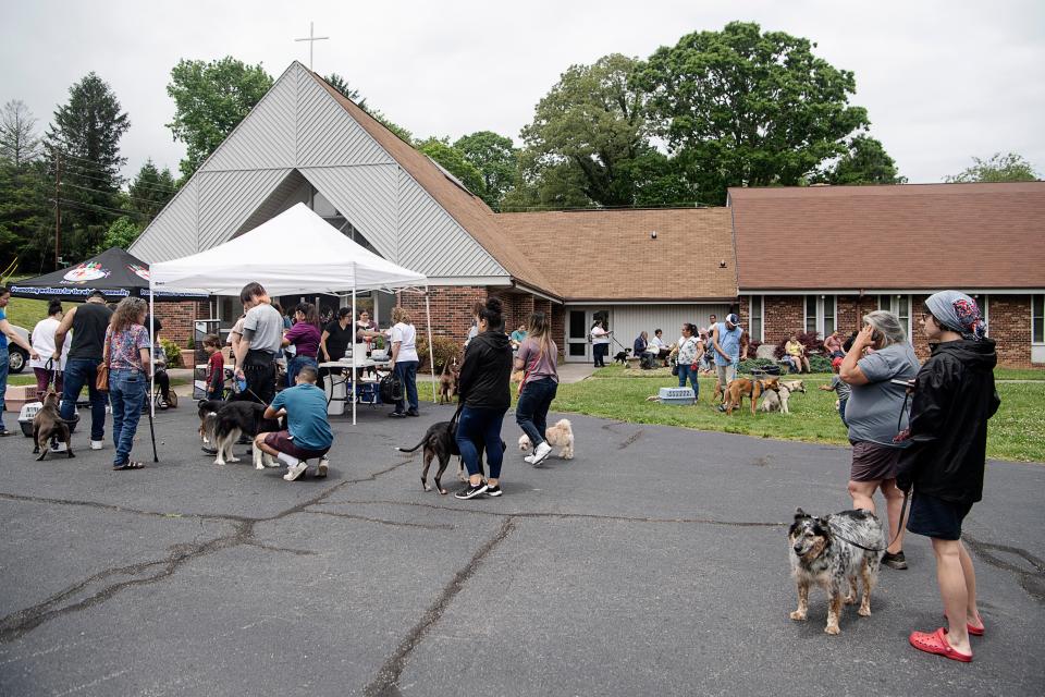 People and their pets wait to be seen by a veterinarian at Emma Fellowship Church May 17, 2023.