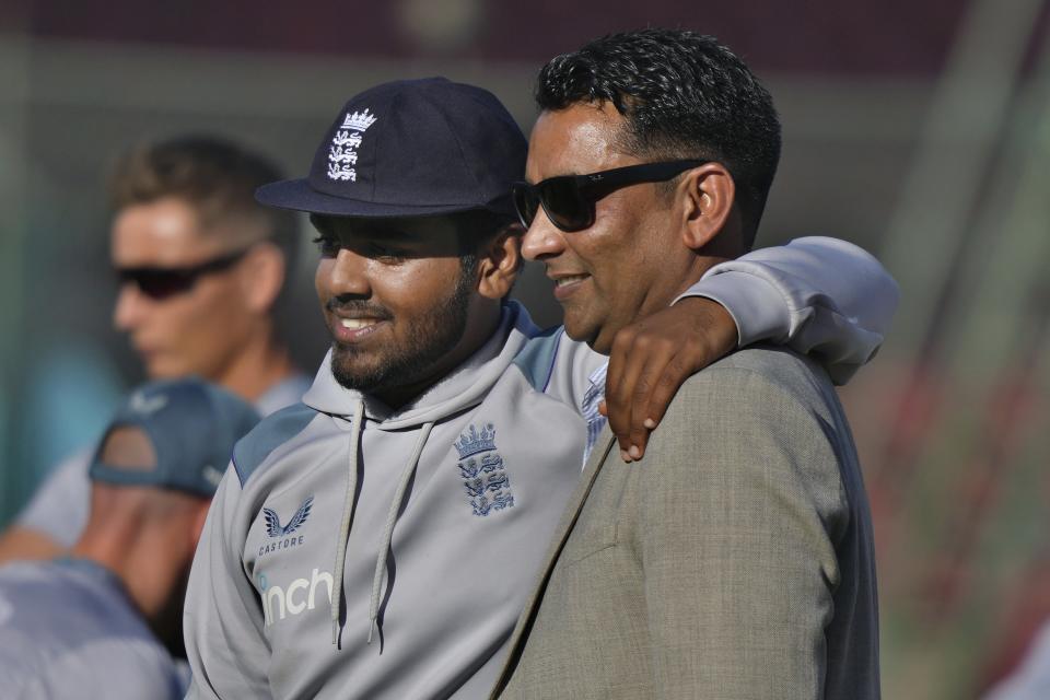 England's Rehan Ahmed, left, poses for photograph with his father Naseem Ahmed after receiving test cap prior to start of third test cricket match between England and Pakistan, in Karachi, Pakistan, Saturday, Dec. 17, 2022. (AP Photo/Fareed Khan)