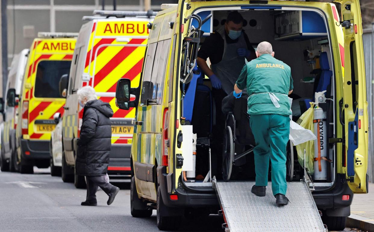 Paramedics work inside an ambulance parked outside the Royal London hospital - TOLGA AKMEN/ AFP