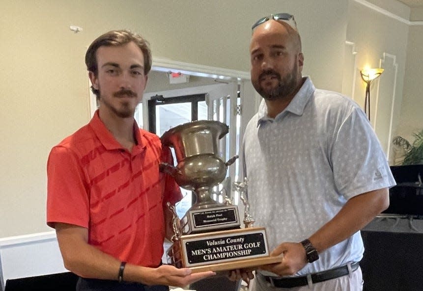 Derek Sanderson (left) accepts the County Am's Ralph Pool trophy from host pro Jason Pomroy at Spruce Creek Country Club.