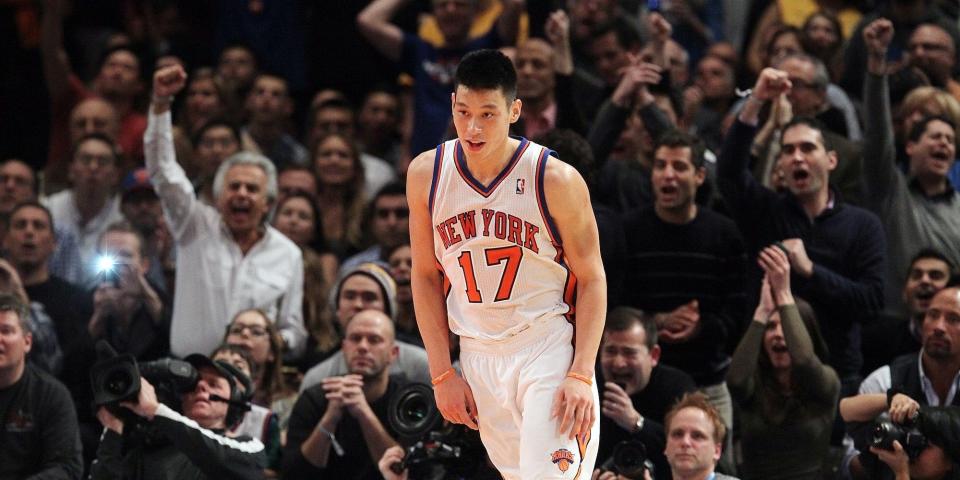 Jeremy Lin runs down the court smiling as fans cheer behind him during a Knicks game in 2012.