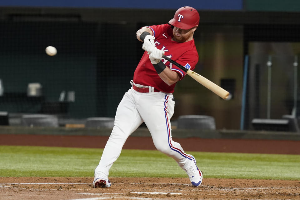 Texas Rangers' Kole Calhoun hits a single during the second inning of the team's baseball game against the Boston Red Sox in Arlington, Texas, Friday, May 13, 2022. (AP Photo/LM Otero)
