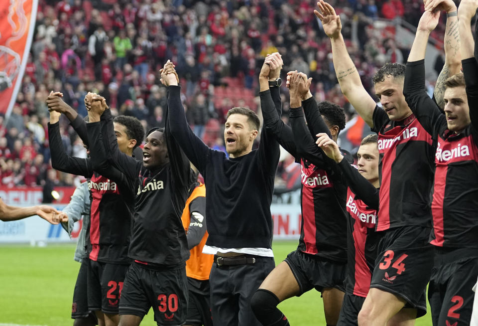 FILE - Leverkusen's head coach Xabi Alonso, centre, celebrates with his team after winning the German Bundesliga soccer match between Bayer Leverkusen and TSG Hoffenheim at the BayArena in Leverkusen, Germany, on March 30, 2024. Excitement was building in Leverkusen, Germany on Sunday ahead of local team Bayer Leverkusen’s expected Bundesliga title win after an outstanding season so far. (AP Photo/Martin Meissner, File)