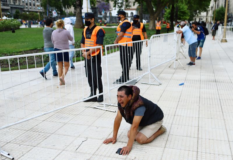 Foto del jueves de un hombre llorando cerca de la gente que se acerca a la Casa Rosaada en Buenos Aires para despedir a Diego Maradona