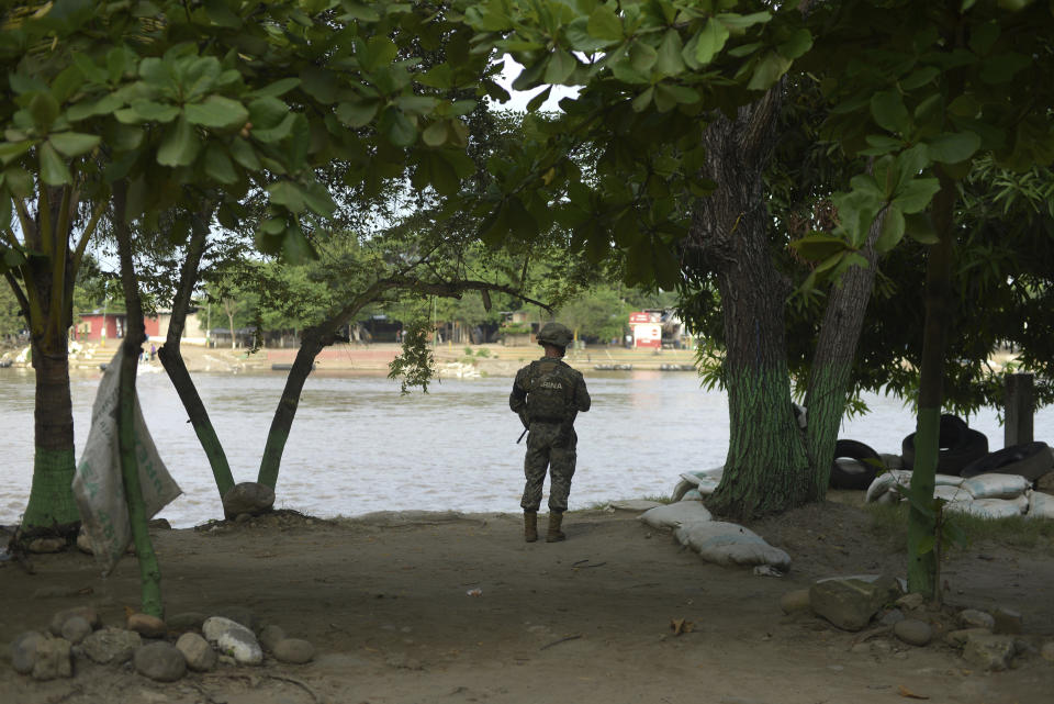 A Mexican marine stands guard on the Suchiate River, watching for migrants crossing from Guatemala to Ciudad Hidalgo, Mexico, Sunday, June 16, 2019. Mexico faces heightened pressure from the U.S. to reduce the surge of mostly Central American migrants through its territory. (AP Photo/Idalia Rie)