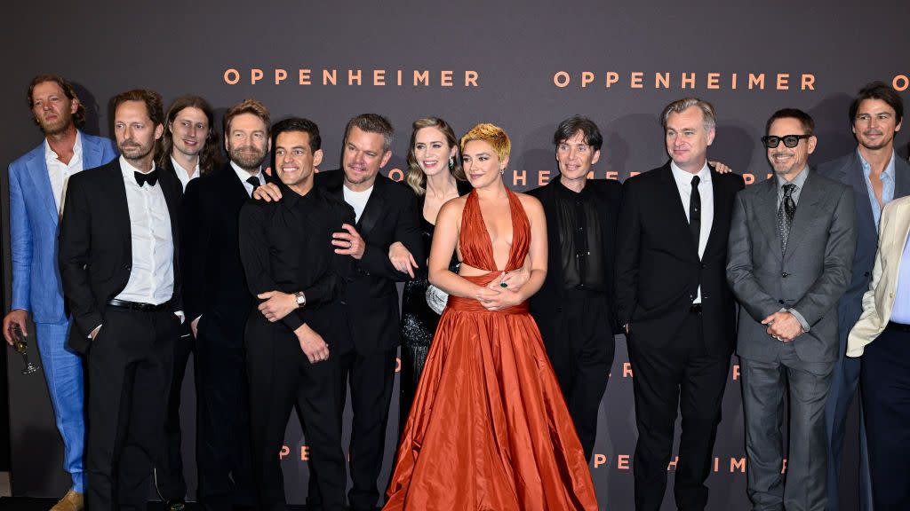 the cast and production crew of oppenheimer standing together for a photo at the films premiere