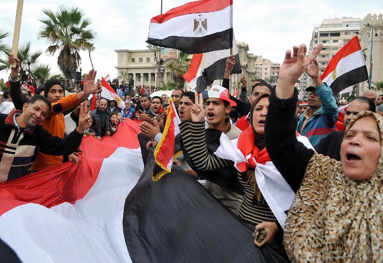 Egyptian supporters of the military-installed government wave national flags and shout slogans in Alexandria on January 25, 2014