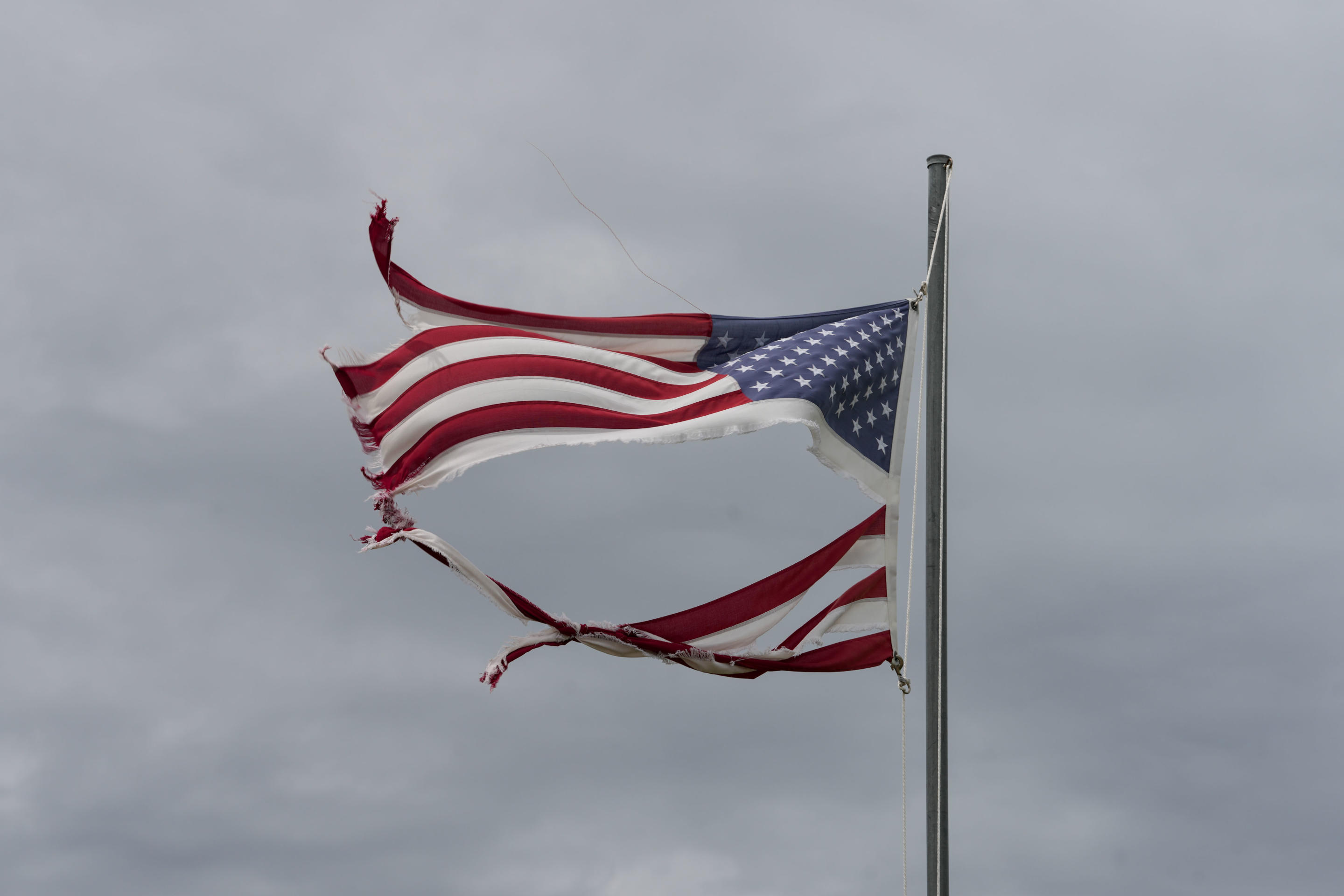 A tattered American flag flies in the wind after Hurricane Beryl made landfall near Matagorda, Texas, on Monday.  8, 2024, near Matagorda. (Jon Shapley/Houston Chronicle via Getty Images)