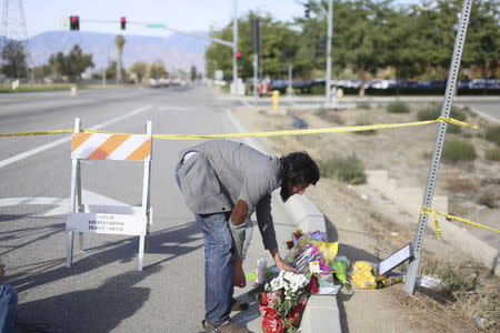 Faisal Abdullah lays flowers at a makeshift memorial site to honor victims following Wednesday's shooting attack in San Bernardino, California December 5, 2015. REUTERS/Sandy Huffaker