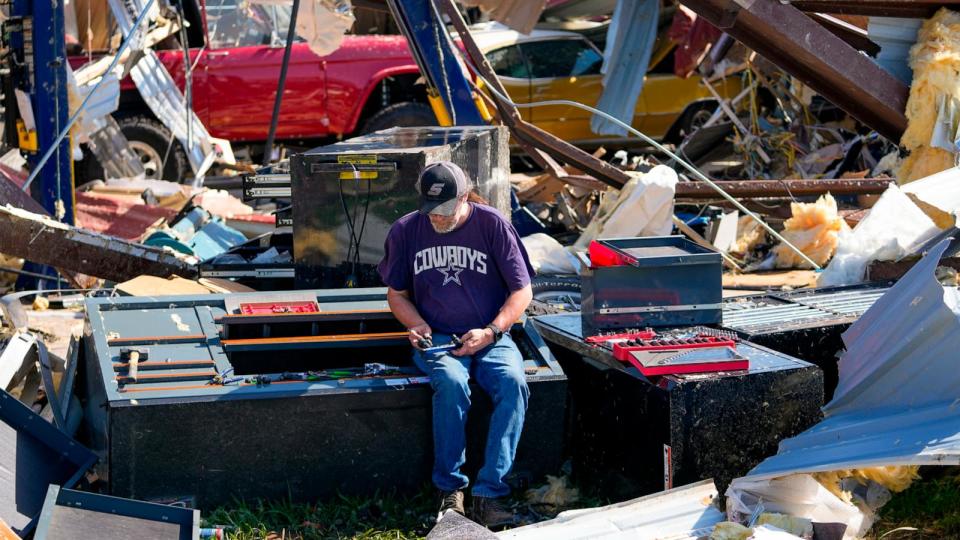PHOTO: An employee of a body shop collects tools from near damage the morning after a tornado rolled through, May 26, 2024, in Valley View, Texas. (Julio Cortez/AP)