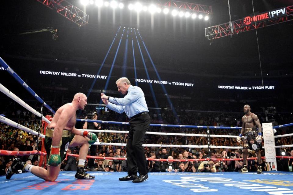 Tyson Fury receives a count from the referee in his first fight with Deontay Wilder.